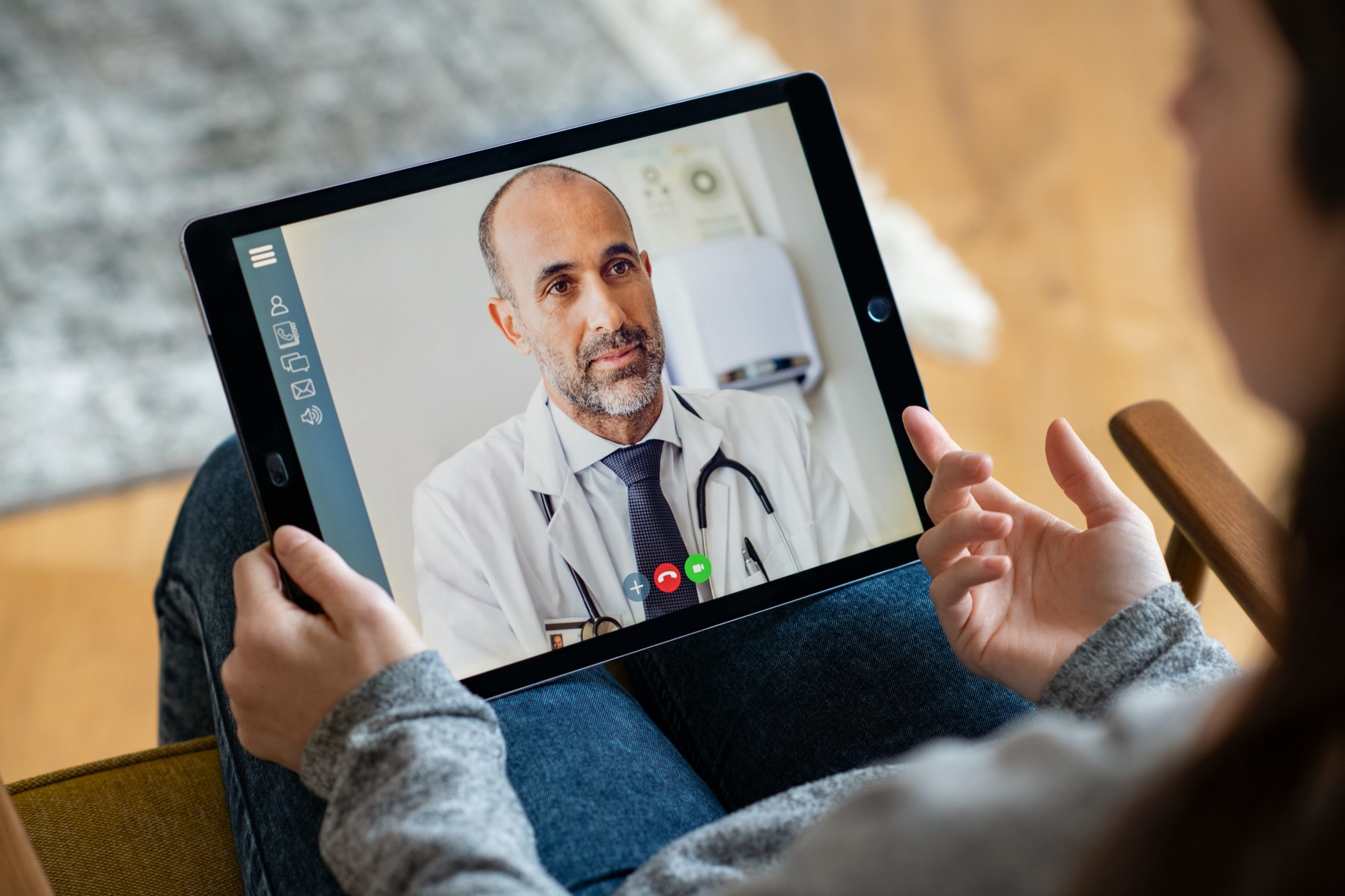 Patient talking to a doctor on a tablet in a virtual medical meeting