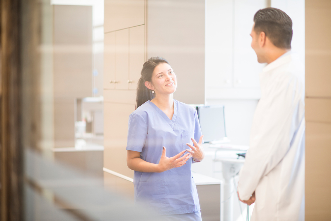 Female dental assistant communicating with a dentist