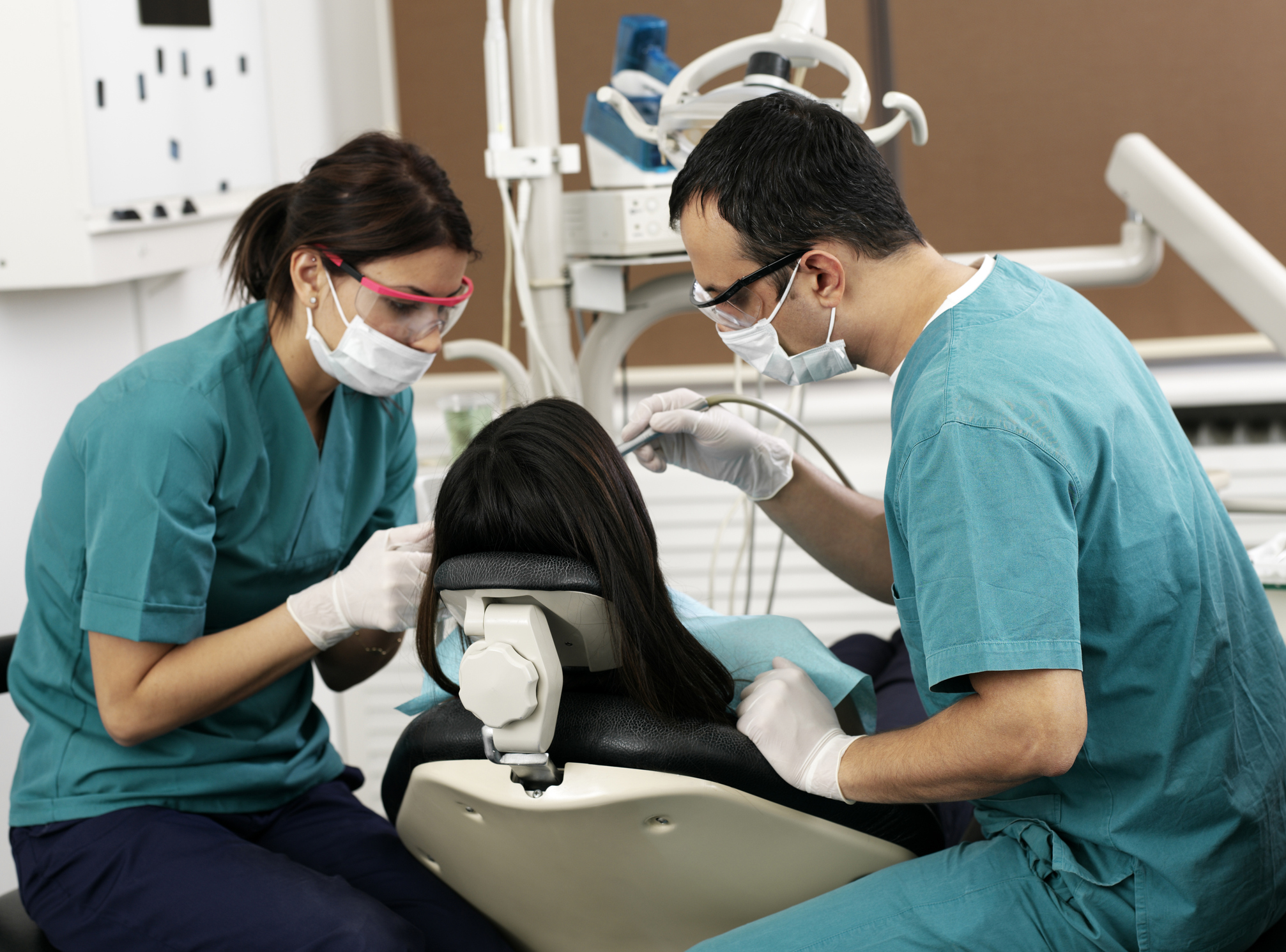 Two dental assistants working on patients teeth