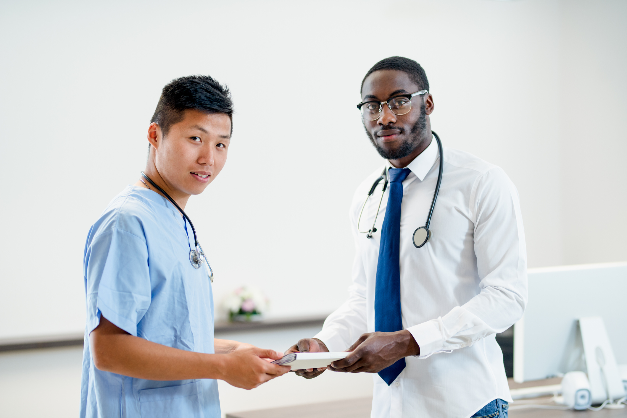 Male Medical Assistant and a Male Doctor holding records