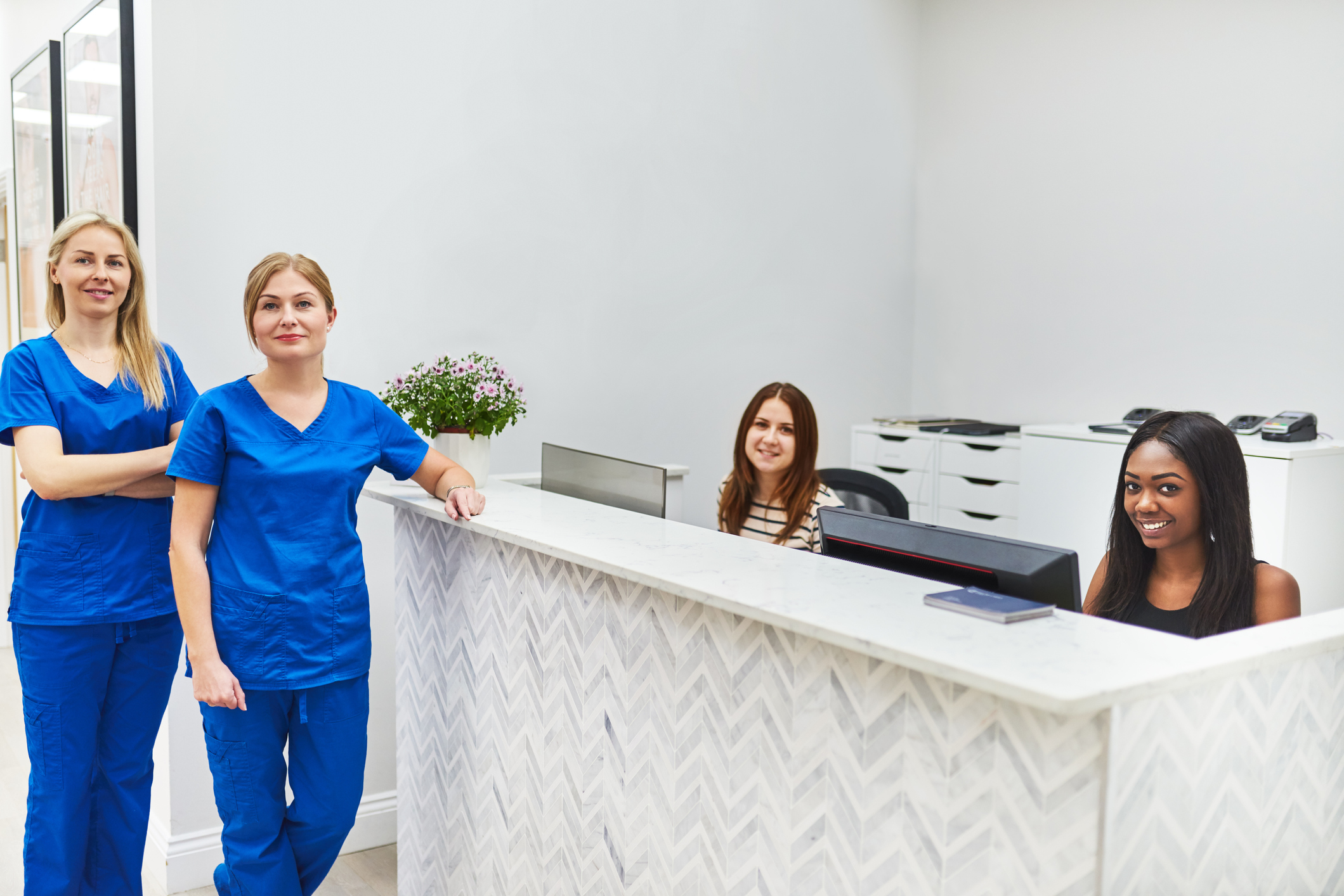 4 smiling female Medical Office Assistant students in a medical office