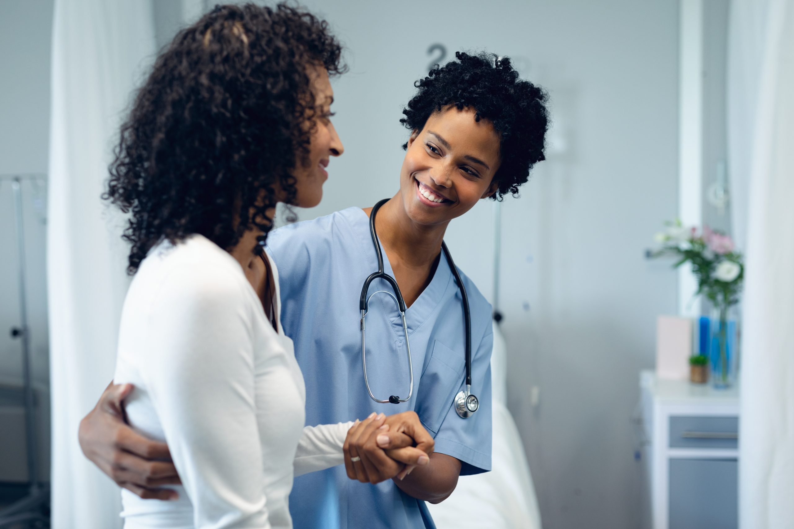 Female Medical Assistant helping a female Patient