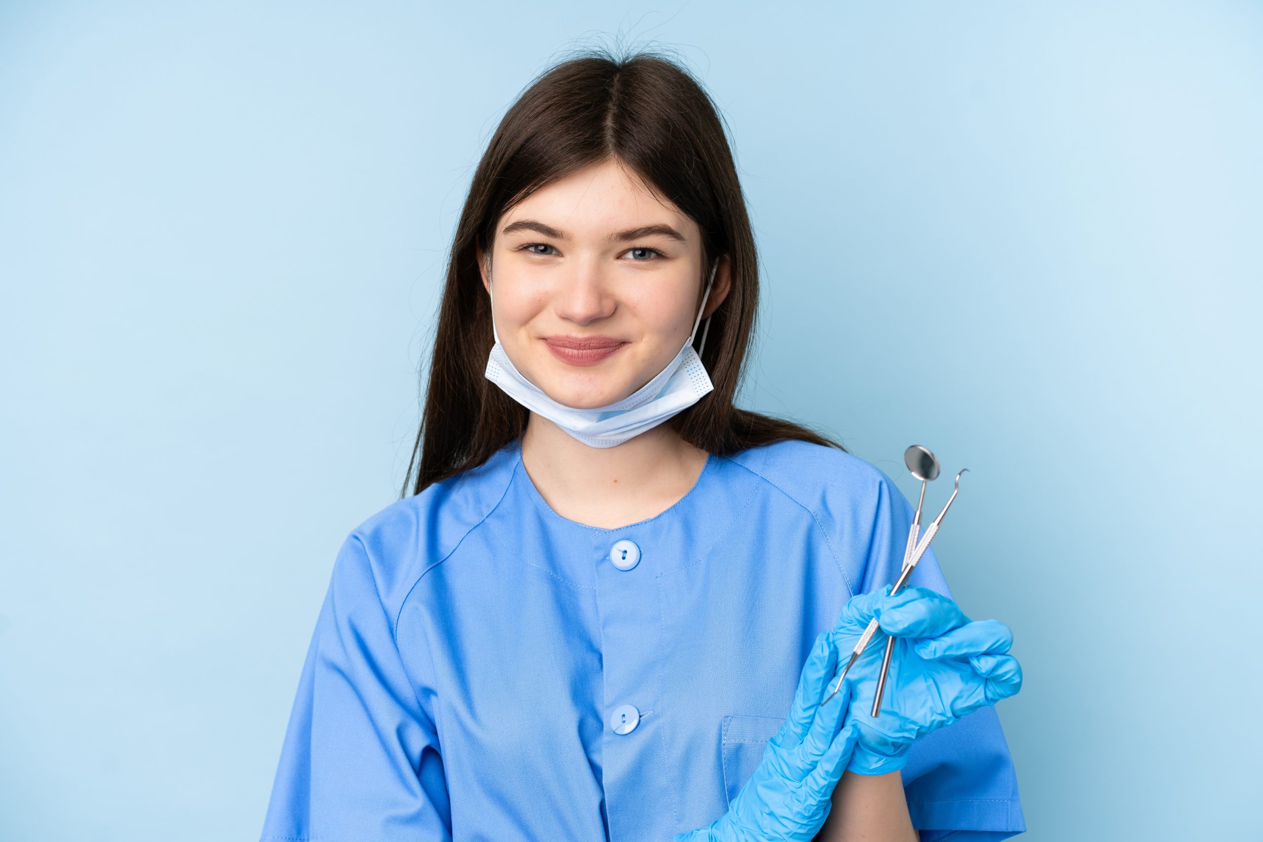 young female smiling in blue scrubs