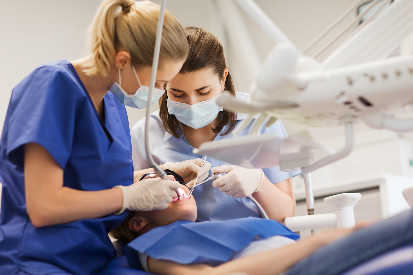 female dentists treating patients teeth