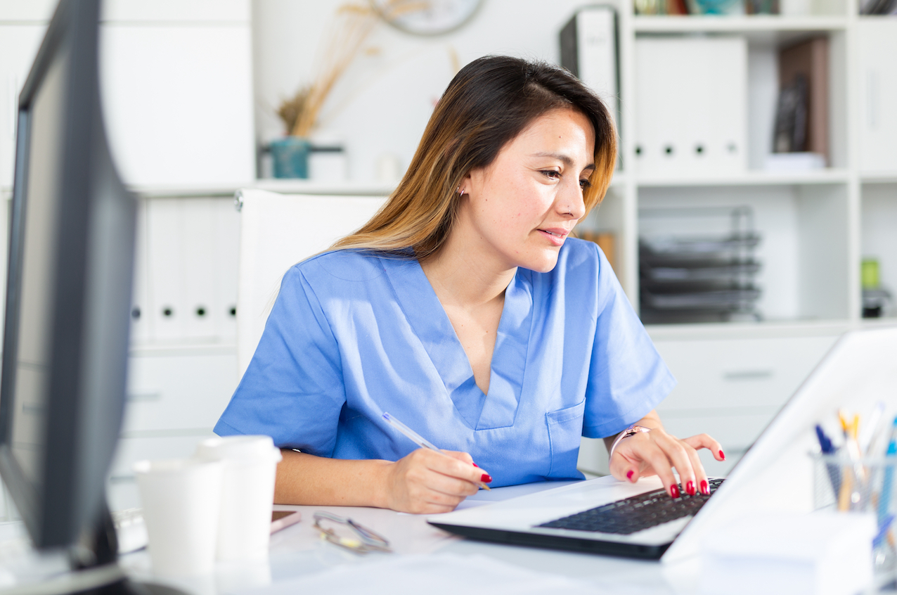 A Female latina medical assistant on a laptop