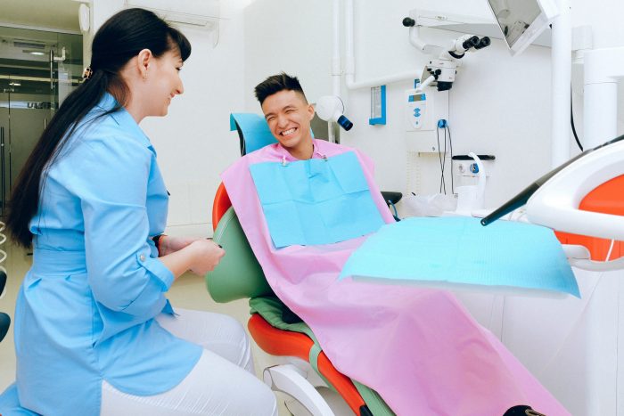 Cheerful patient sitting in dental chair in clinic