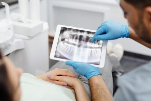 Person Wearing Blue Latex Gloves Holding White Tablet Computer