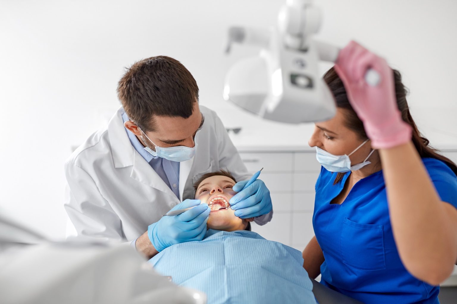 A Dentist and Dental Assistant working on a kids teeth